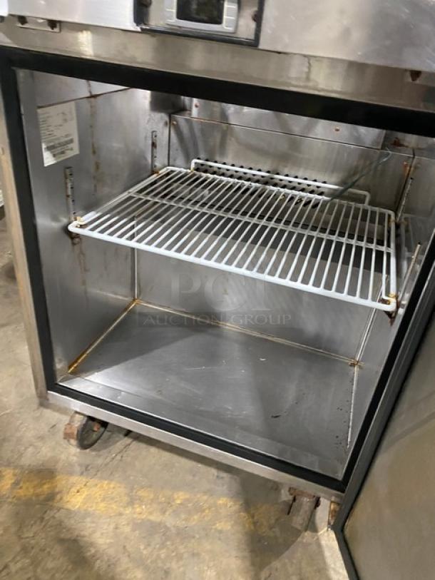 Migali stainless steel single door refrigerated bain marie prep table with poly-coated rack, cutting board, on casters.