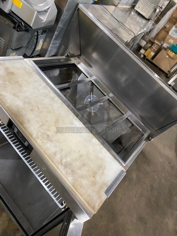 Migali stainless steel refrigerated bain marie prep table with cutting board, poly-coated rack, and casters.