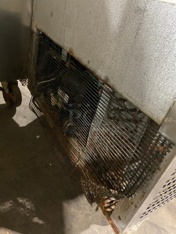 Atosa commercial stainless steel undercounter worktop freezer, poly coated wired rack, on casters, visible wear.