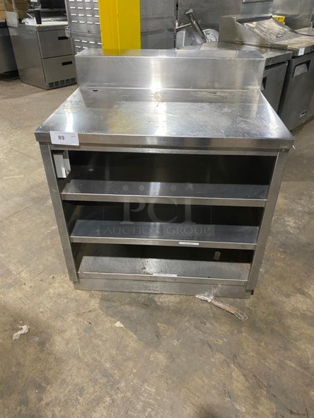 Commercial stainless steel enclosed cabinet table with multi-tier shelving, backsplash, rear shelving; good condition.