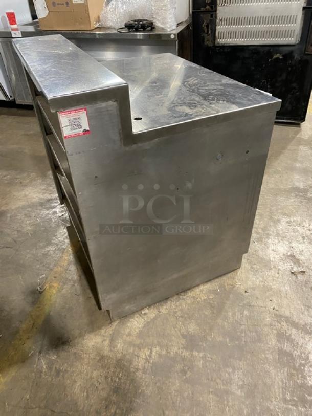 Commercial stainless steel multi-tier dry worktop table with enclosed cabinet, rear shelving, and backsplash.