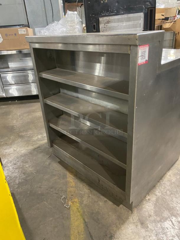 Commercial stainless steel enclosed cabinet with multi-tier shelving, dry worktop, backsplash, and rear shelving. Rugged condition.
