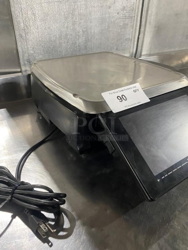 Hobart HTi7LH4 commercial black electric price computing scale/printer combo with stainless steel worktop and dual displays.
