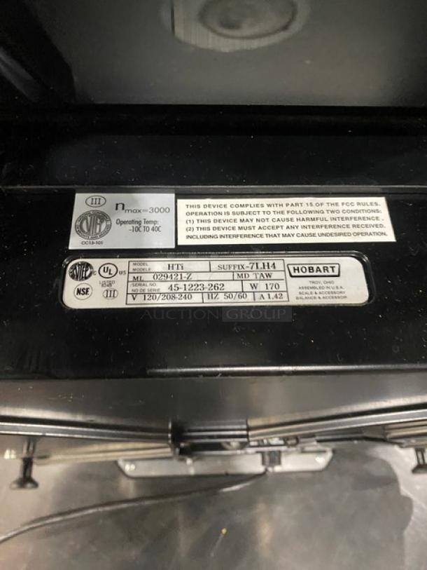 Hobart HT-Series price computing scale and printer combo, model HTi-7LH4. Features stainless steel worktop, operator and customer display. Serial number 45-1221-558. 120/208-240V.