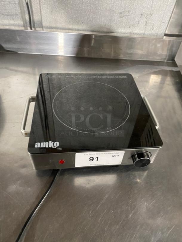 Amko AK-IR15 stainless steel electric countertop single-burner ceramic infrared cooktop. Features a control knob and warning label.