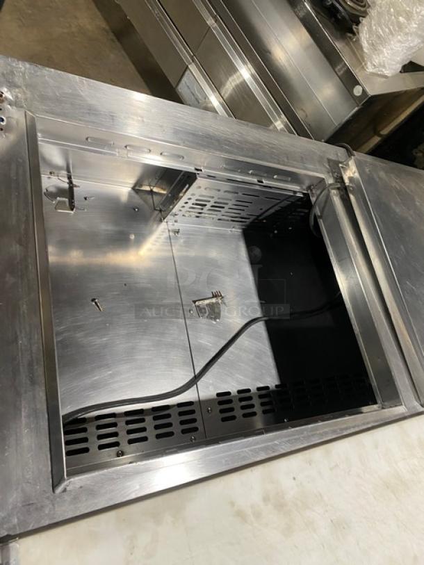 Turbo Air TST-60SD-24-N refrigerated prep table, stainless steel, open top view. Includes cutting board, chrome rack, on casters.