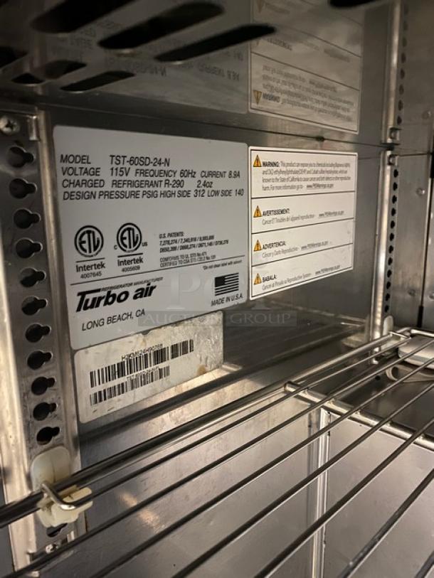 Turbo Air TST60SD24N commercial 2-door refrigerated prep table with shelves and visible model label, in good condition.