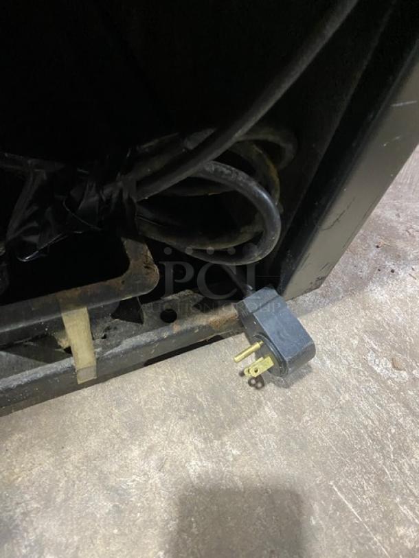 True GDM-35EM commercial refrigerator power plug, black, showing 115V connection; part of energy-efficient unit.