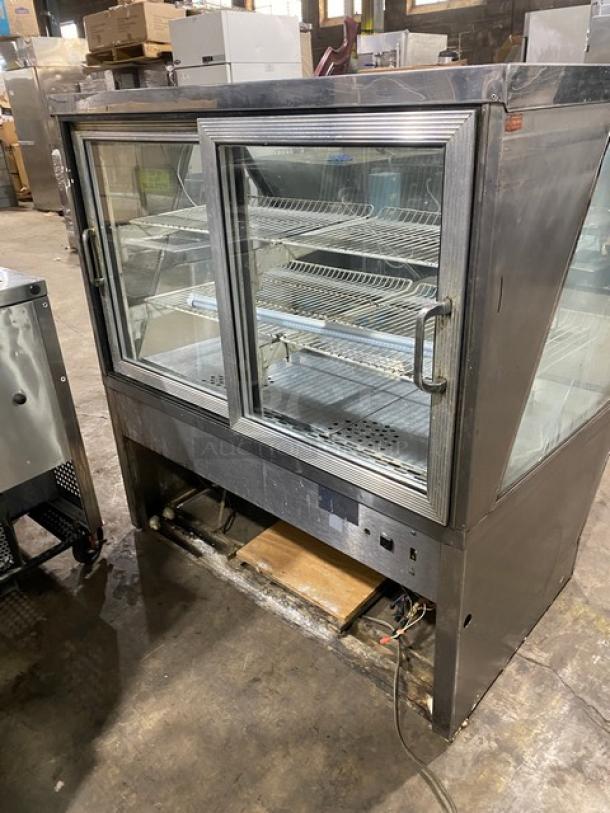 Commercial stainless steel bakery display with slanted glass, poly coated wired racks, and rear double glass sliding door.