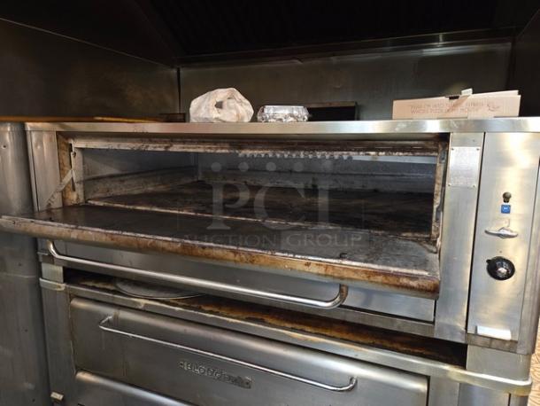 Blodgett commercial stainless steel double-stacked pizza deck oven on legs, visible wear, with Blodgett branding on the front.