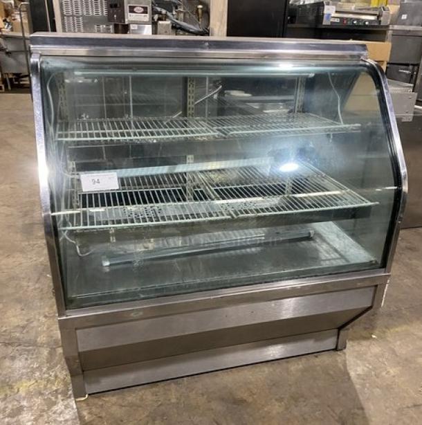 Commercial stainless steel bakery display with slanted glass, poly-coated wired racks, and rear double glass sliding doors.