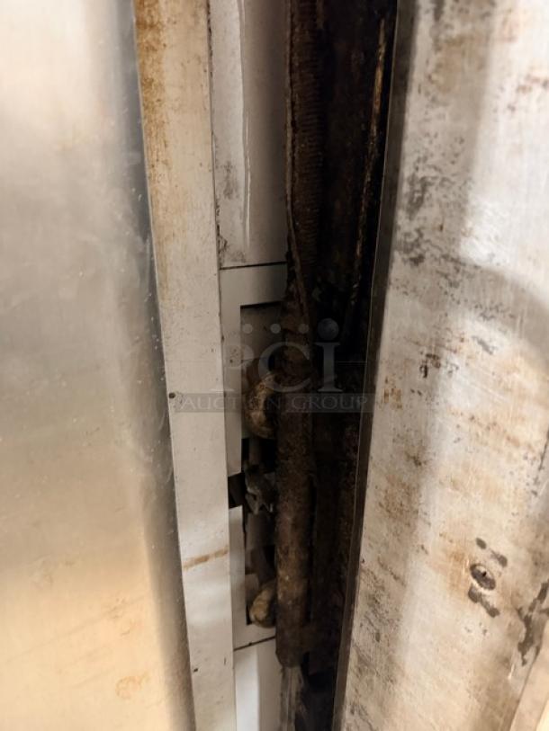 Blodgett 1060 double-stacked pizza oven, stainless steel, natural gas, pre-owned, on legs, edge view with visible wear.