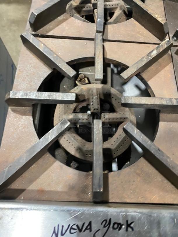 Jade Range Bistro Series commercial 4-burner range in stainless steel, natural gas, with wired oven rack, mounted on legs. Visible wear.