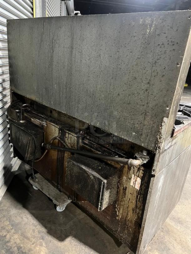 U.S. Range commercial 10-burner gas range with double ovens, stainless steel, includes backsplash and wired oven rack, used condition.