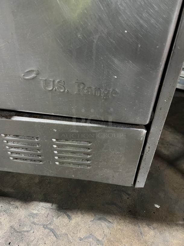 U.S. Range stainless steel 10-burner gas range with double oven, back splash, and wired rack; slight wear, embossed brand name.