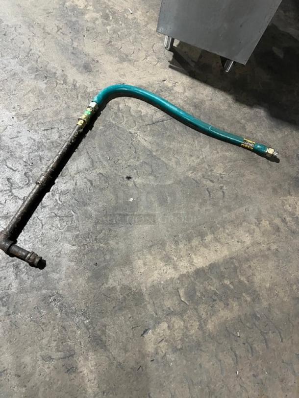 Gas hose for Avantco FF300N fryer, shown on a concrete floor, with visible metal and rubber sections.