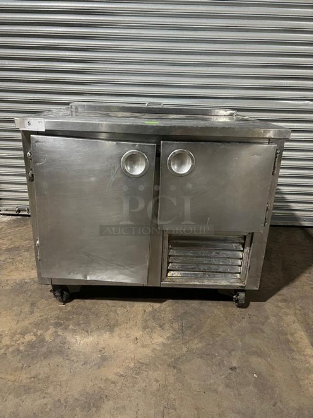 Commercial stainless steel refrigerated salad/sandwich prep table, 1-1/2 door, poly coated rack, on casters, in used condition.