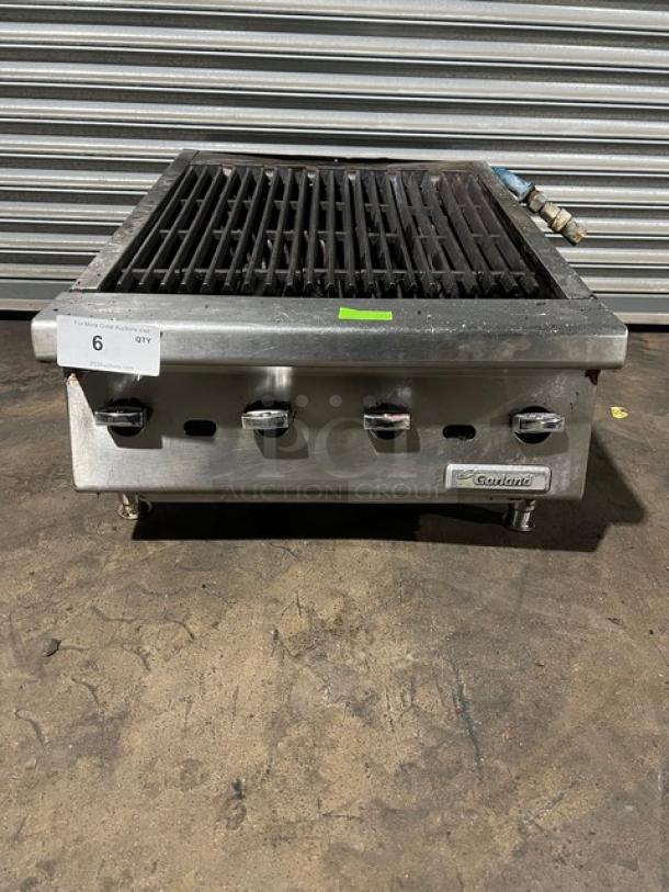 Garland stainless steel gas-powered countertop char broiler with legs; features control knobs and brand label; used condition.