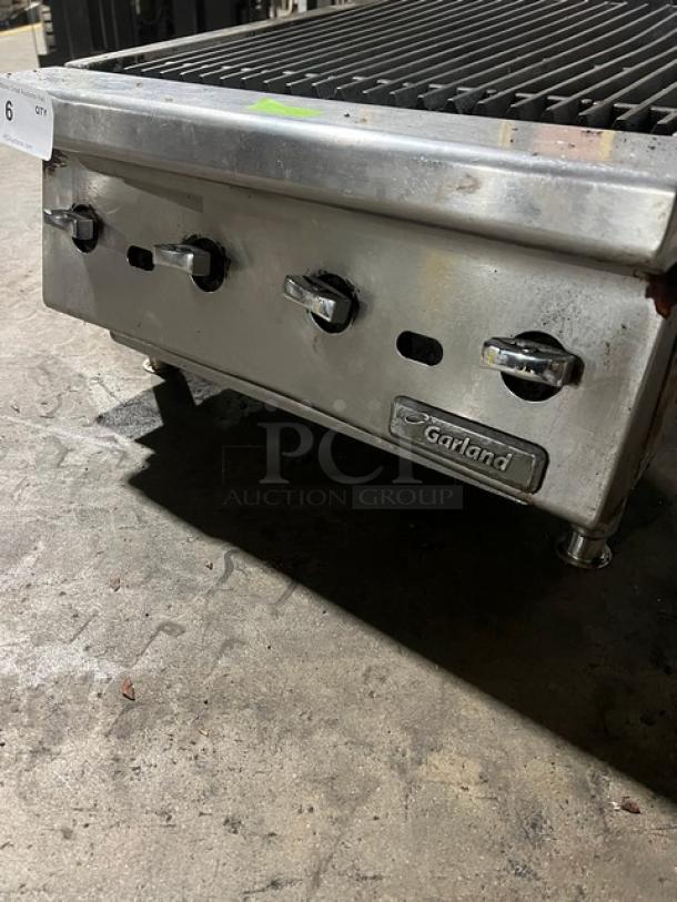 Garland stainless steel gas countertop char broiler with legs, featuring control knobs and Garland logo. Good condition.