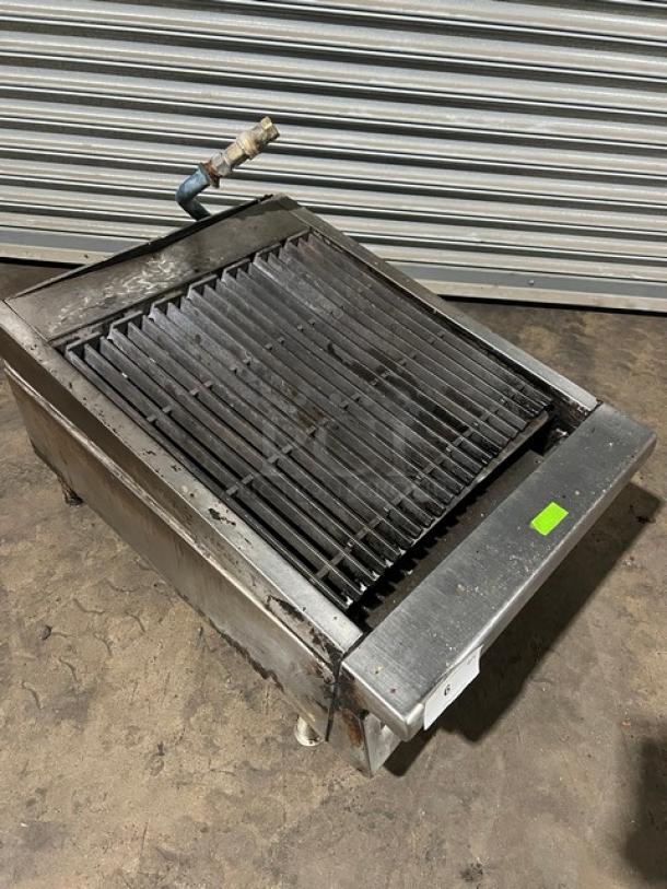 Garland commercial stainless steel gas-powered countertop char broiler on legs, showing wear, sturdy, ideal for restaurants.