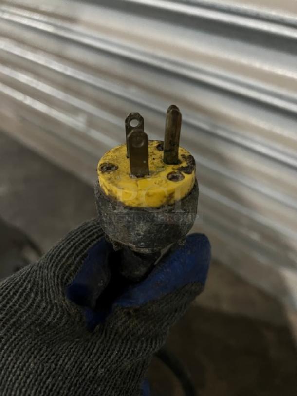 Power plug for Continental SW60 worktop refrigerator, shown with a gloved hand. Plug condition is visibly worn.