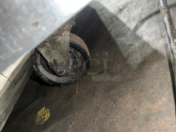 Close-up of a caster wheel on a Continental SW60 worktop refrigerator. Caster shows wear and dirt.