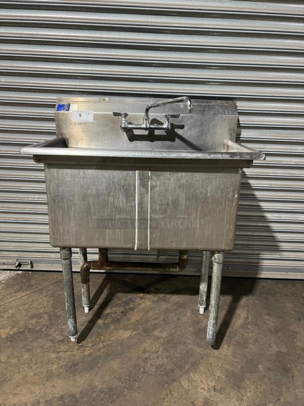 L&J commercial stainless steel 2-compartment prep sink with swing spout swivel faucet, on sturdy legs, visible wear.