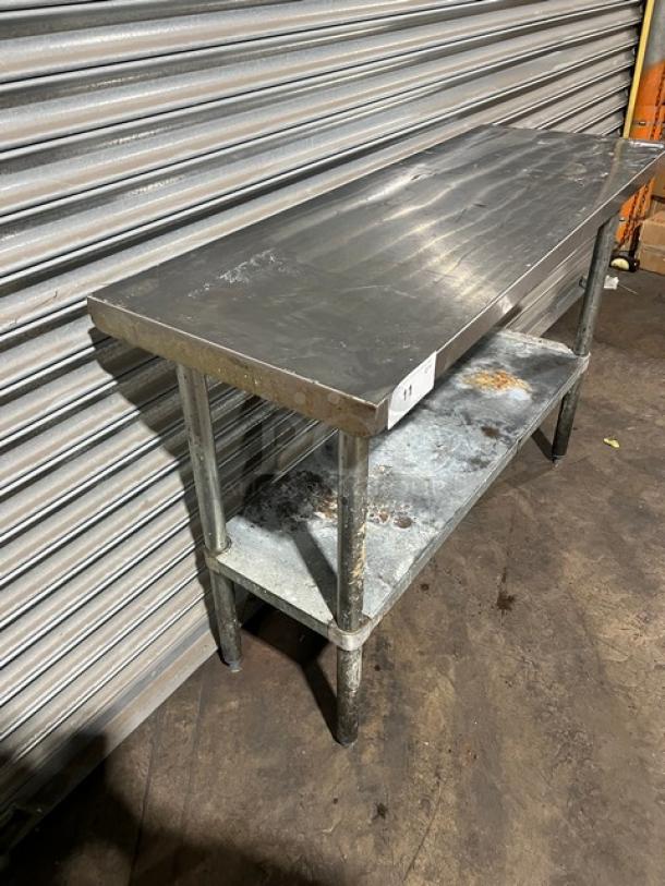Commercial stainless steel worktop table with single undershelf. Features sturdy legs, visible wear. Ideal for industrial use.