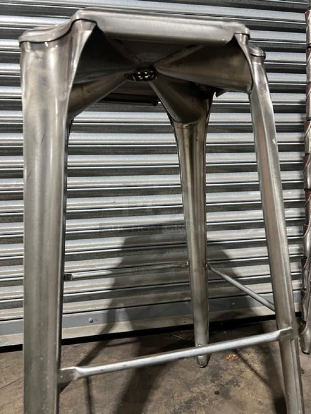 Stackable bar-height stool, metal frame, industrial design, silver finish, durable construction, good condition.