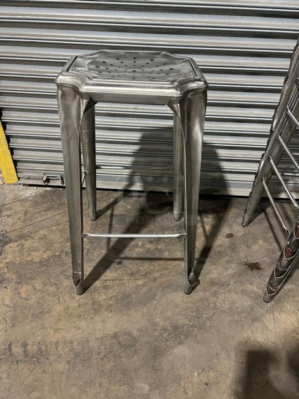 Commercial stackable bar-height stool in metallic finish, industrial design, durable, excellent condition.