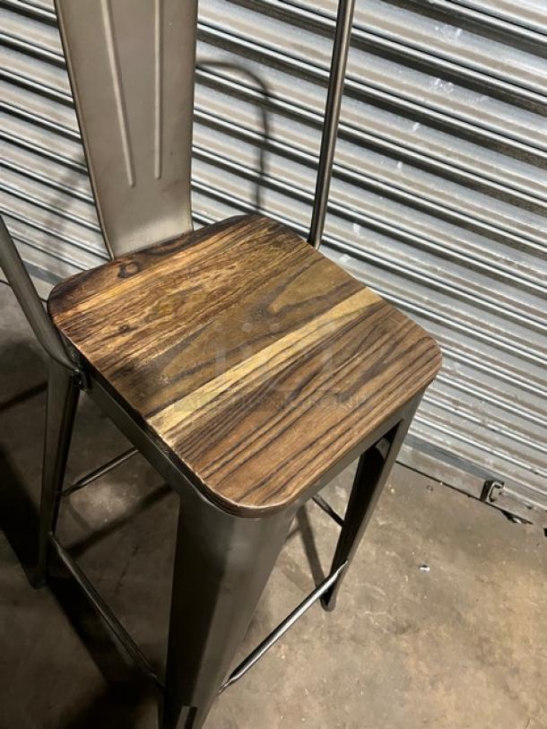 Stackable bar-height chair with metal frame and wood seat. Suitable for commercial use. Good condition.