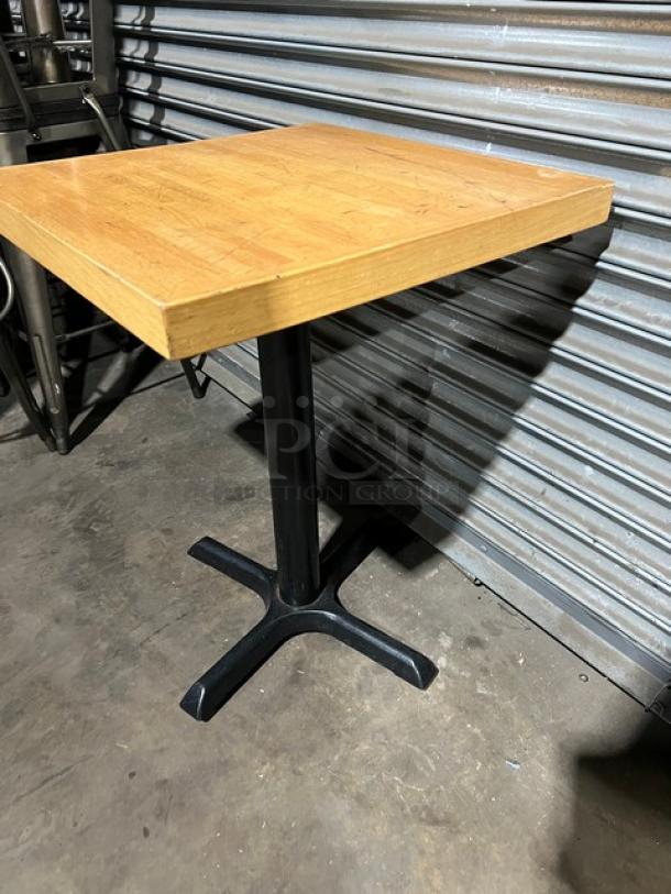 Commercial dining-height table with wooden top and black metal pedestal base. Good condition. Suitable for restaurant use.