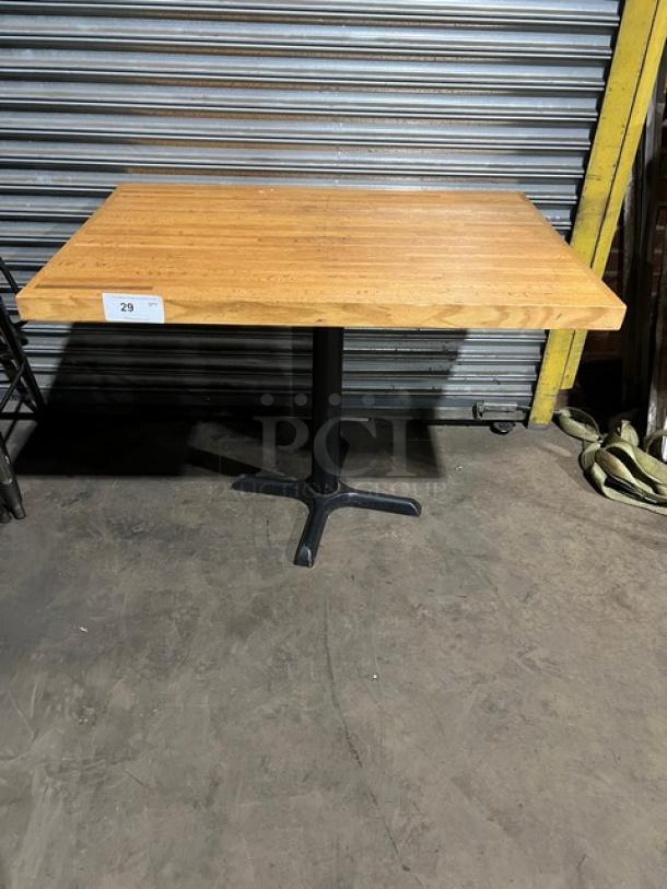 Commercial wooden rectangular tabletop with a pedestal base, in good condition. Auction label with number 29 attached.