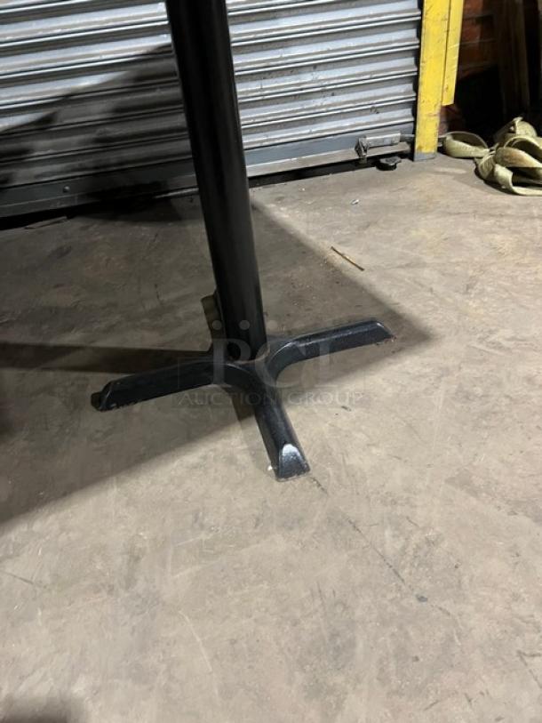 Commercial wooden rectangular tabletop with sturdy black pedestal base, suitable for industrial use.