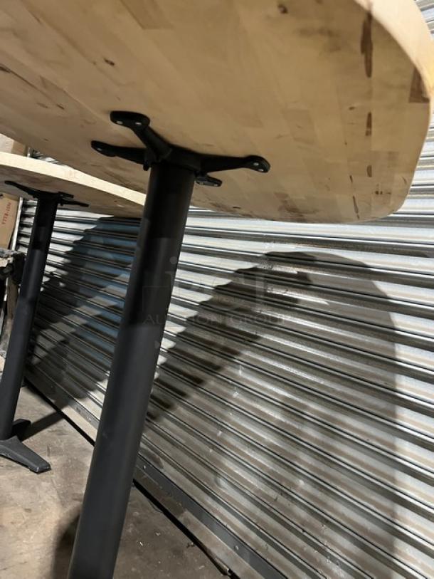 Commercial wooden oval tabletop with pedestal base; sturdy construction, natural finish, ideal for restaurants or cafes.