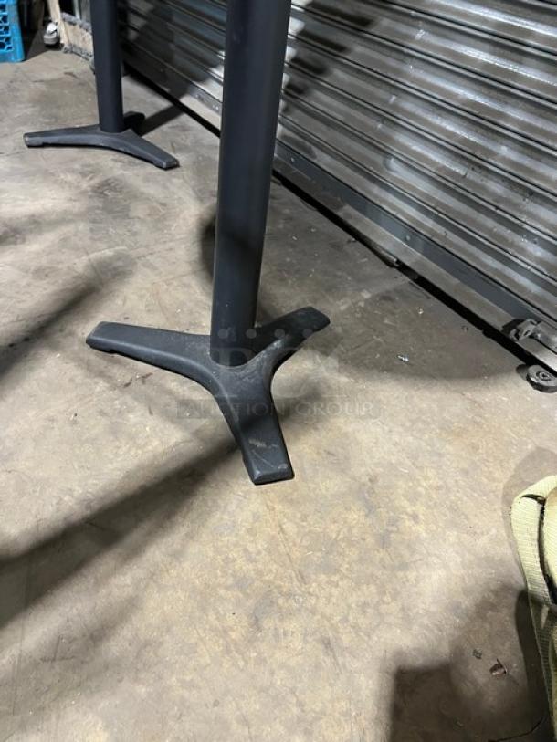 Commercial wooden oval tabletop with a sturdy pedestal base. Slight wear visible; ideal for restaurant use.