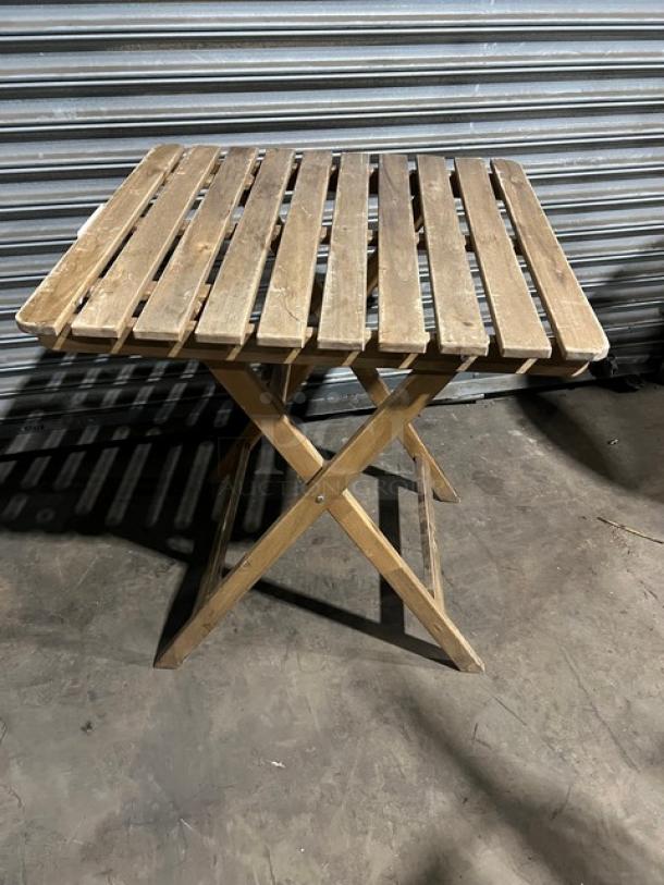 Commercial wooden folding table, slatted design, good condition, natural finish, sturdy foldable legs, suitable for events.