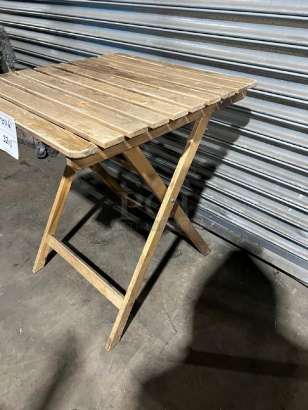 Commercial wooden folding table, natural finish, sturdy with slatted top. Good condition, ideal for versatile uses.