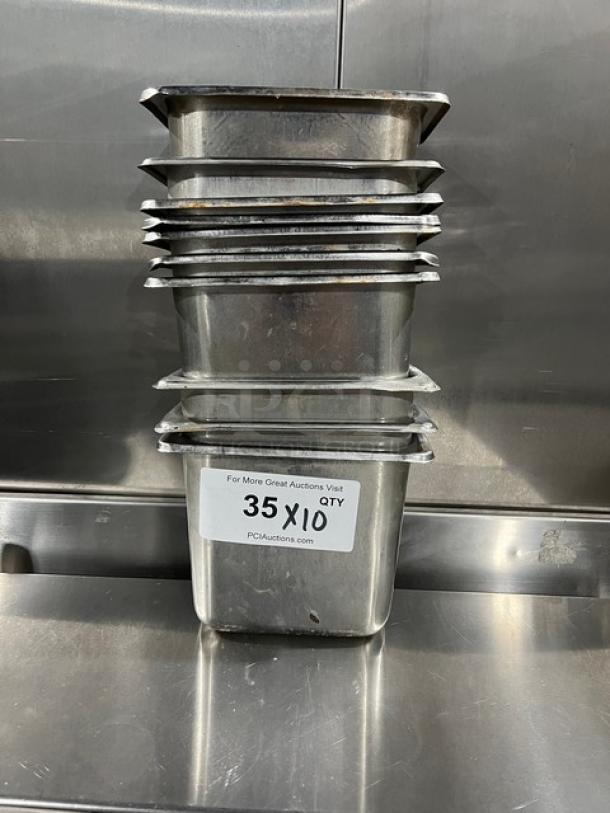 Stack of commercial stainless steel hotel pans, gently used, featuring a label "35 X 10" indicating quantity.