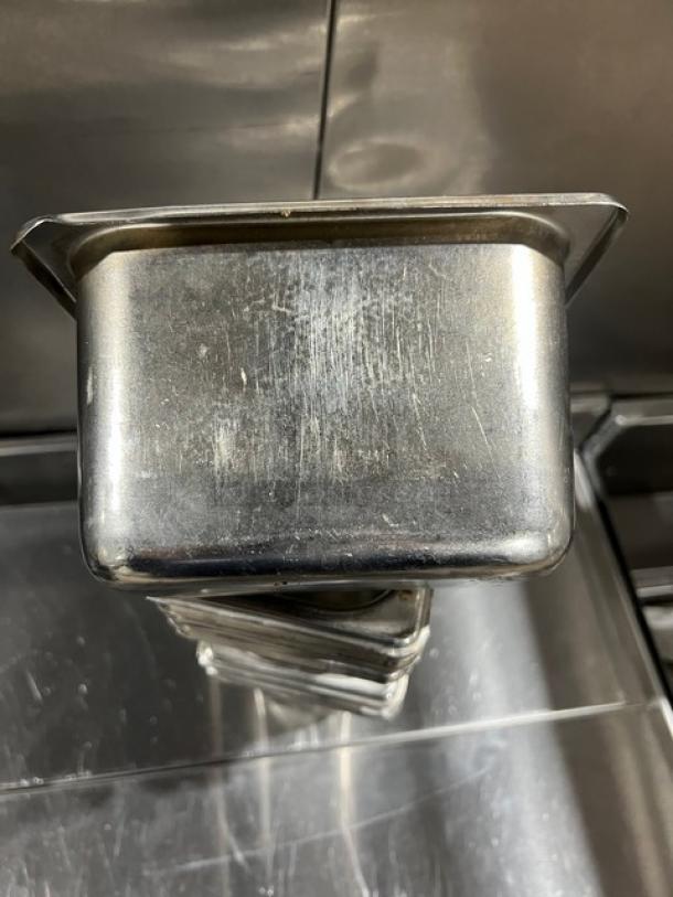 Commercial stainless steel hotel pan, used condition with surface scratches, stackable design, ideal for steam tables.