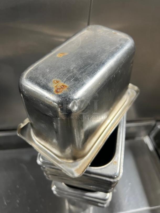 Commercial stainless steel hotel/steamtable pan, showing signs of use with rust spots. Stackable design, durable construction.