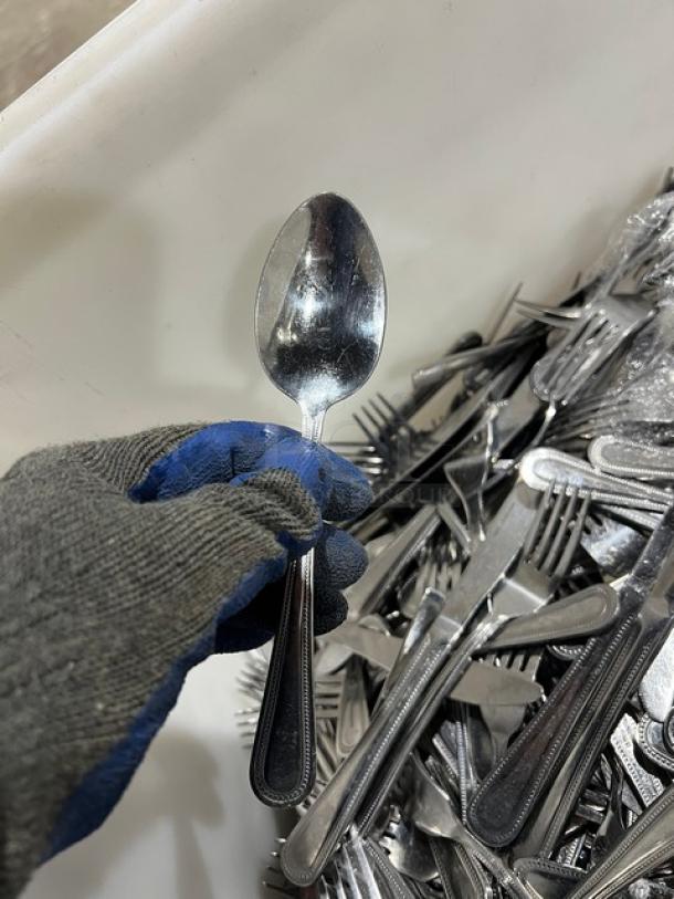 Commercial stainless steel dining utensils including forks, knives, and spoons. Good condition, durable design.