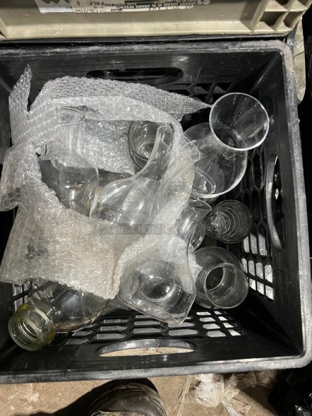 Eight glass bottles for serving water or juice in a crate. Includes bubble wrap for protection. Ideal for commercial use.