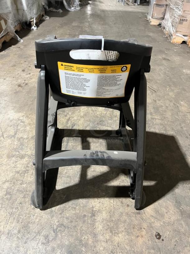 Rubbermaid Commercial black restaurant highchair model FG780608BLA on casters. Visible caution label. Good condition.