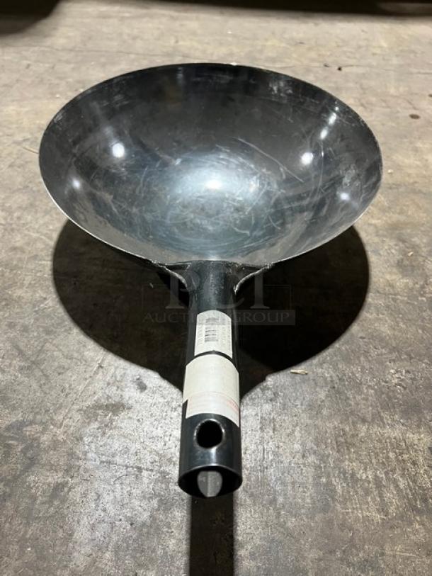 Commercial black non-stick frying pan with a sleek design, visible label on handle, in good condition.