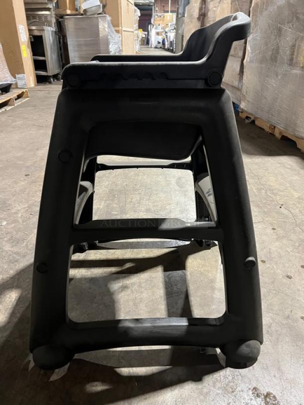 Rubbermaid Commercial black restaurant highchair on casters, durable plastic, good condition, easy mobility.