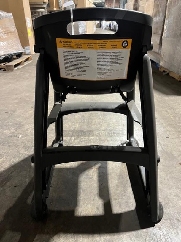 Rubbermaid Commercial black restaurant highchair on casters, durable plastic, visible safety label, used condition.