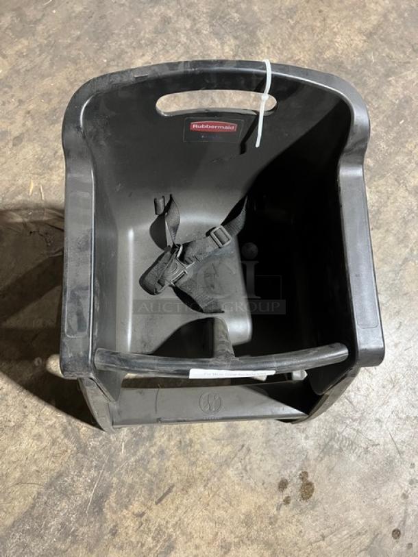 Rubbermaid Commercial black restaurant highchair on casters, features safety straps, integrated grip handle, visible brand label.