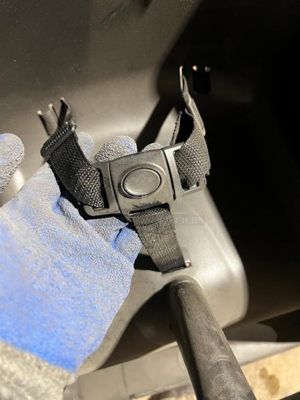 Rubbermaid Commercial Black Highchair, durable plastic, notable safety buckle, on casters for mobility, used condition.