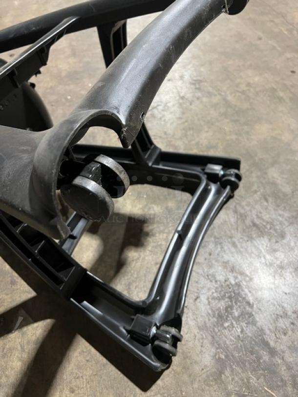 Rubbermaid Commercial black highchair base on casters, showing structural detail. Appears worn, suitable for restaurant use.